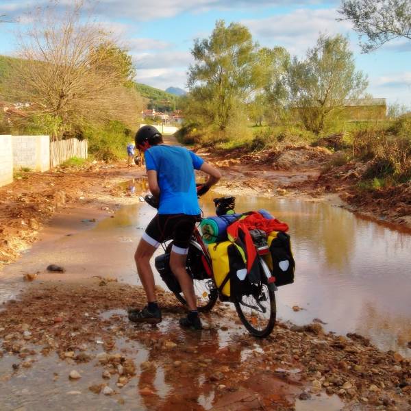 Cruzando a pie con la bici un camino embarrado en Albania